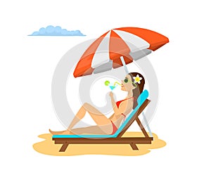 Woman relaxing on the sun chair under beach umbrella on vacation, sunbathing, drinking cocktail.