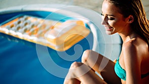 Woman relaxing and sun tanning by the swimming pool