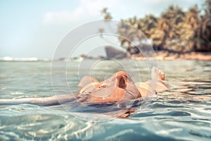 Woman relaxing and sunbathing meditating in tranquil sea beach palm trees travel tropical vacation lifestyle