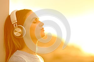 Woman relaxing at sunset listening to music