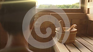 Woman relaxing and sweating in hot sauna