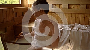 Woman relaxing and sweating in hot sauna