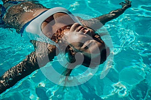 Woman relaxing swimming pool. Happy woman in a blue swimsuit floating in the pool, look form above