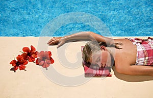 Woman relaxing at the swimming pool side