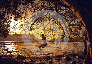 Woman relaxing on a swing on the beach