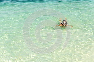 Woman relaxing in turquoise waters at tropical beach