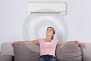 Woman Relaxing Under The Air Conditioner