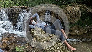 Woman relaxing at a waterfall in Lagoons of Ruidera Natural Park.