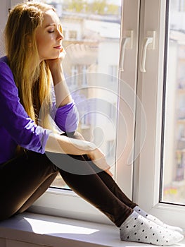 Woman relaxing on windowsill