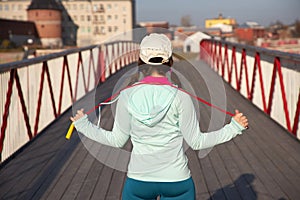 Woman relaxing on a wooden bridge after cardio exercise outdoors, taking care of her body,