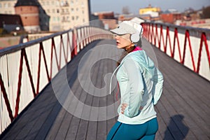 Woman relaxing on a wooden bridge after cardio exercise outdoors, taking care of her body,
