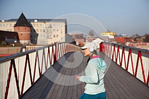 Woman relaxing on a wooden bridge after cardio exercise outdoorswoman jumping on a wooden bridge, cardio exercise outdoors