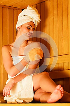 Woman relaxing in wooden sauna room