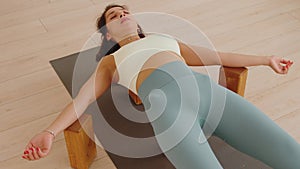 A woman relaxing on the yoga blocks in the savasana pose and breathing in studio