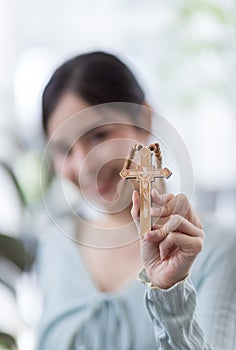 Woman in religion concept. Hands praying to the GOD while holding a crucifix symbol . Nun holding a cross in his hands. Human hand