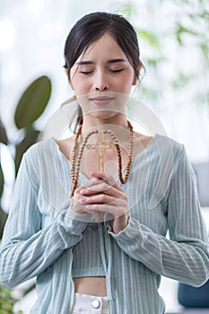 Woman in religion concept. Hands praying to the GOD while holding a crucifix symbol . Nun holding a cross in his hands. Human hand