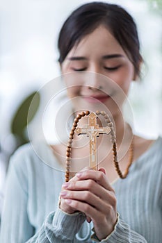 Woman in religion concept. Hands praying to the GOD while holding a crucifix symbol . Nun holding a cross in his hands. Human hand