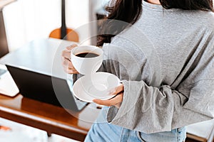 Woman relxing time while working and hold cup of coffee at working place