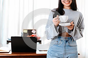 Woman relxing time while working and hold cup of coffee at working place