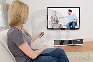 Woman With Remote Control In Front Of Television