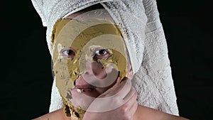 The woman removes from the face of the green algae mask.
