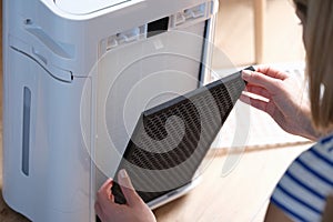 Woman removes filter from air purification system