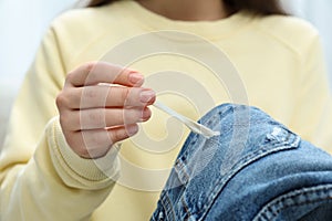 Woman removing chewing gum from jeans, closeup