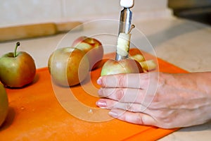 Woman removing the core and pips from the juicy apple with metal apple corer