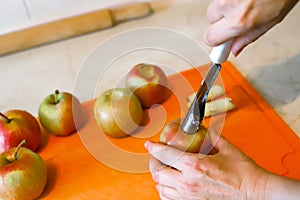 Woman removing the core and pips from the juicy apple with metal apple corer