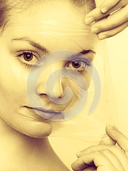 Woman removing facial peel off mask.