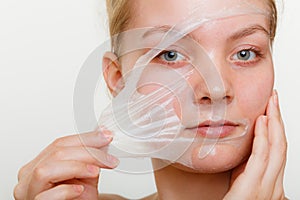 Woman removing facial peel off mask