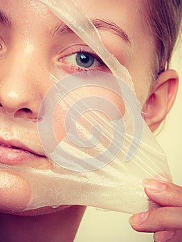 Woman removing facial peel off mask