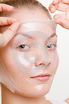 Woman removing facial peel off mask.