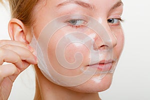 Woman removing facial peel off mask.