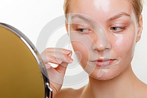 Woman removing facial peel off mask.