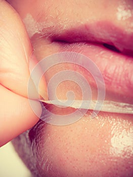 Woman removing facial peel off mask closeup