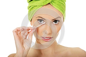 Woman removing make up with cotton bud.