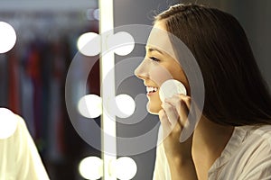 Woman removing make up in a mirror