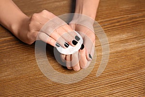 Woman removing nail polish at table