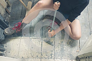 Woman removing paint from floorboards photo