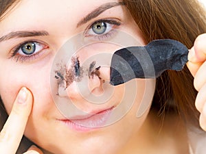 Woman removing pore strips mask from nose