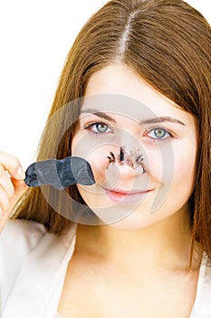 Woman removing pore strips mask from nose