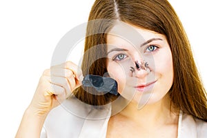 Woman removing pore strips mask from nose