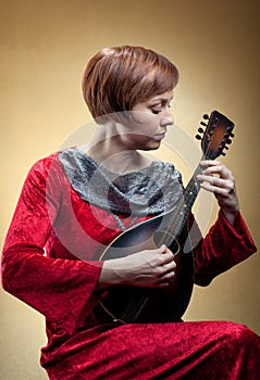 Woman in renaissance costume playing mandolin