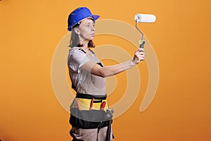 Woman renovator painting walls with roller brush