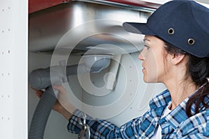 Woman repairing bathroom sink pipe