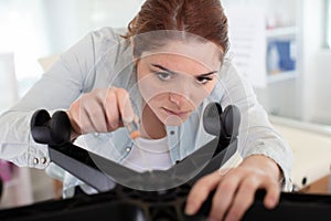 woman repairing chair by hand with removable castors