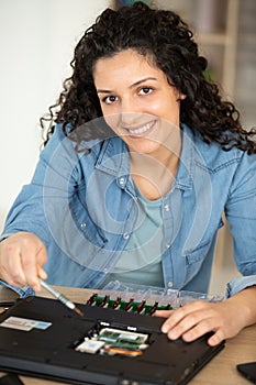 woman repairing laptop with precision tools