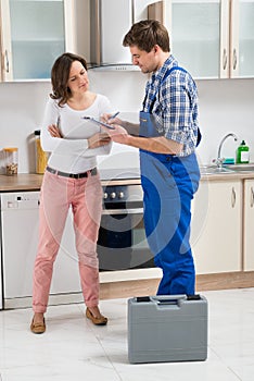 Woman And Repairman In Kitchen