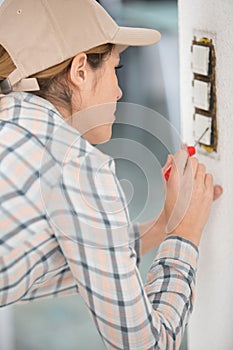 woman repairs outlets in new apartment